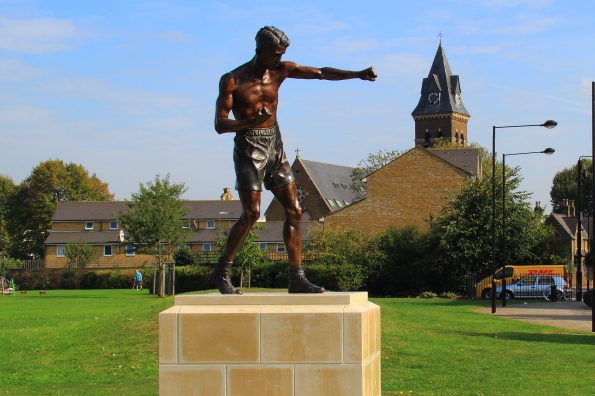 Bronze statue of Teddy Baldock with St Michael's Church behind him