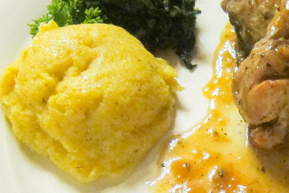 Polenta with spinach and a knuckle of pork or stinco in Trentino, Italy