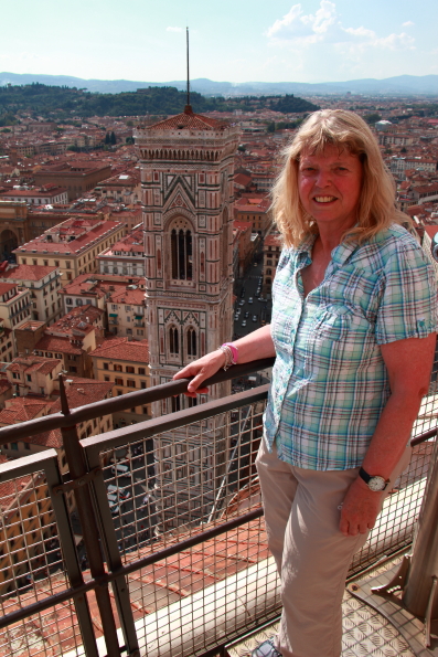 Valery standing outside the cupola of the cathedral in Florence with Giotto's tower in the background